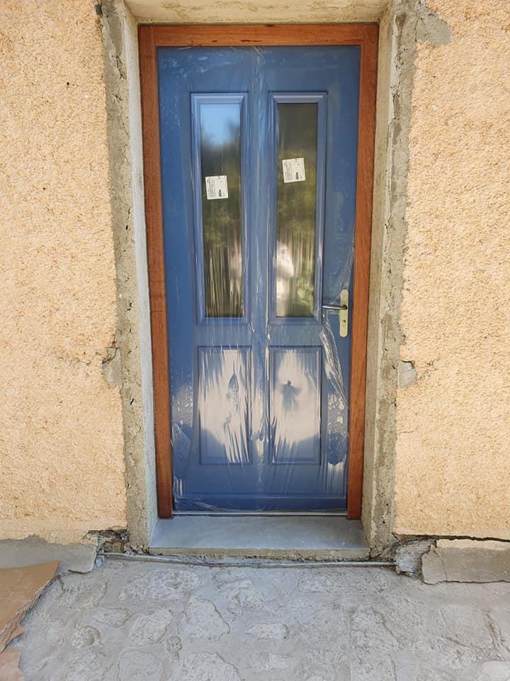Porte d'entrée bleue qui ajoute du caractère à la façade de la maison